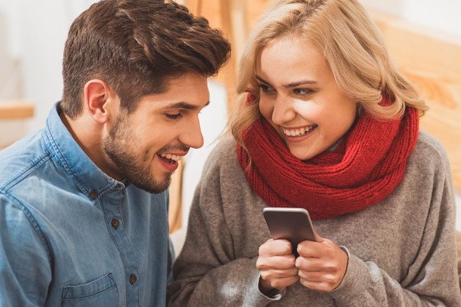 Парень смотрит в телефон девушки